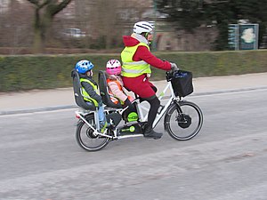 Un longtail Bike43 transportant deux enfants à l'arrière.