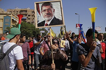 Mursi-loyale Demonstrantin mit Porträt des vom Militär gestürzten Präsidenten.[143]