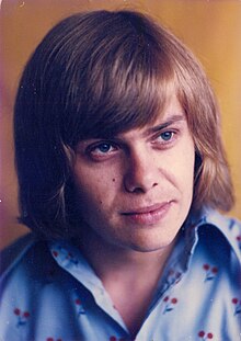 close-up of Jiří Schelinger wearing a patterned shirt, looking left of camera