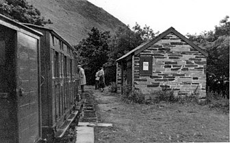 A train in Abergynolwyn station, with the station's second, slate, station building, looking west. 3 August 1951.