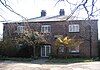 A brick building in two storeys with a French window