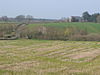 A few buildings scattered amongst fields and trees.