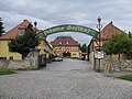 „Adams Gasthof“ mit Saalanbau einschließlich der gesamten nach drei Seiten geschlossenen Hofanlage, mit Hofeinfahrtspfeilern und großer Hofmauer, Gartenanlage, Brunnen und Teich