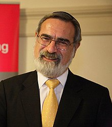 Rabbi Jonathan Sacks smiling at the camera.