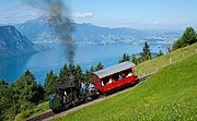 29.–31. KW Die Lokomotive 7 der Vitznau-Rigi-Bahn, weltweit eine der letzten betriebsfähigen Dampflokomotiven mit Stehkessel, unterwegs auf das Bergmassiv Rigi zwischen Grubisbalm und Freibergen, Zentralschweiz. Im Hintergrund liegt der Vierwaldstättersee.