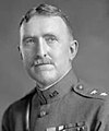 Man facing forward in high neck uniform with ribbon bars on