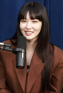 Chungha looks at the camera during her interview on the Daebak Show with Eric Nam.