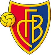 FC Barel crest of a shield, the left half red and the right half blue. The shield is outlined with gold and in the centre in gold letters it reads "FCB". On the left side of the logo is a gold football.