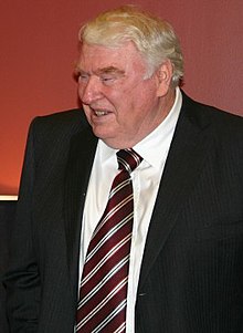 John Madden smiling, wearing a suit