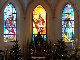 Aktuelle Fenstergruppe am Hochaltar, links St. Nikolaus, Mitte Auferstandener Jesus Christus, rechts der seliggesprochene Kaspar Stanggassinger vom Kälberstein