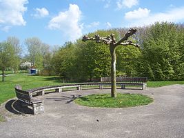 Hofje met speeltafels. Gaasperpark (voormalige Floriade). Deze ronde bank sluit het geheel af. Jaartal en maker(s) onbekend.