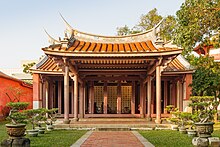 Önünde çit bulunan ayrıntılı bir Çin tapınağının fotoğrafı.