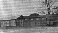 A black and white photo of the entrance to a sports ground