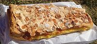 A Jésuite is a triangular, flake pastry filled with frangipane cream and topped with sliced almonds and powdered sugar.