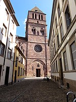 St. Thomas in Strasbourg, Westfassade, kurz nach 1200: Die abgesehen vom Obergeschoss jüngsten Öffnungen, unteres Glockengeschoss sind frühgotisch, Biforien mit Zusatzokulus, runde Mittelstützen mit ziemlich kelchförmigen Kapitellen. Das nur aus Ringen bestehende Maßwerk der Rose ist feingliedriger als damalige Konstruktionen der Île-de-France. Der Überfangbogen der Portalzone ist nur angedeutet spitzbogig, aber innerhalb gibt es zwei sehr spitze Lanzettfenster, interessanterweise mit Monolithaufliegern (*), und mehrere Spitzbögen ohne Relief im Mauerverband. Das kleine Spitzbogenfenster über der Tür enthält passend zu Rose feingliedriges Maßwerk, undzwar ohne Kapitelle. Im Material mag es teilweise erneuert sein, aber Gestalt und Kontext legen nahe, dass sie der ursprünglichne entsprechen.