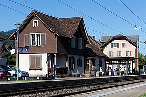 Two-story building with gabled roof on side platform