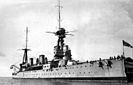 Right oblique view looking up at a two-masted grey warship