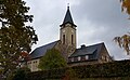 Kirche mit angebautem Pfarrhaus, zwei Kriegerdenkmale vor dem Pfarrhaus und Gedenkstein auf dem Friedhof