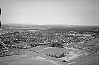 Flyfoto tatt av Widerøe i 1947 viser Tønsberg by med Træleborg og Træleborgodden ved fjordbassenget Træla fremst i bildet. I bakgrunnen helt til venstre sees blant annet Slottsfjellet, byens viktigste landemerke. Foto: Vestfoldmuseene