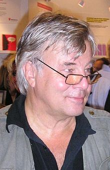 Jan Guillou im Halbprofil auf der Buchmesse in Göteborg. Er trägt eine Brille, ein offenes schwarzes Hemd und darüber eine graue Windjacke.