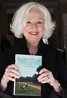 Gildiner holding a copy of the third installment in her memoir trilogy, Coming Ashore