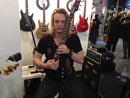 Somers poseert met gitaar (een Aristides 020) op de Frankfurt Musikmesse 2013