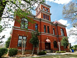 Madison County Courthouse (2014). Das Courthouse entstand 1901 im Stile der Neuromanik. Auf den ausführenden Architekten J. W. Golucke und seine Firma gehen mehr als ein Dutzend Gerichts- und Verwaltungsgebäude in Georgia und Alabama zurück. Das Madison County Courthouse wurde im September 1980 als zweites Objekt im County in das NRHP eingetragen.[1]