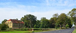 Road in Łukowo, with an old storage building visible