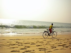 Boy cycling on the beach in Cabo Ledo