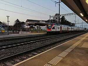 Station platform next to a double-decker train