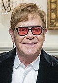 Elton John wearing sunglasses and smiling