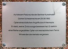 Metallplakette mit der Aufschrift „Auf diesem Platz wurde der Berliner Kunstmaler Günter Schwannecke am 29.08.1992 Opfer eines tödlichen Angriffs durch Neonazis. Er starb, weil er Zivilcourage bewiesen hat. Er steht in einer Reihe ungezählter Opfer von neonazistischem Terror. Wir werden sie niemals vergessen.“