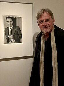 Kai Bird with portrait of J. Robert Oppenheimer at the National Portrait Gallery