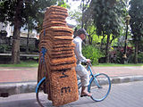 A man hauling coconuts fiber doormats in Indonesia