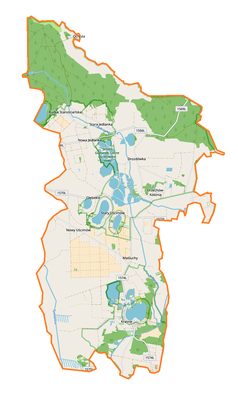 Mapa konturowa gminy Uścimów, na dole znajduje się owalna plamka nieco zaostrzona i wystająca na lewo w swoim dolnym rogu z opisem „Krasne”