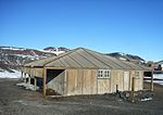 Hütte bei Hut Point, Ross-Insel, errichtet im Februar 1902 durch die britische Discovery-Expedition 1901–1904 unter der Führung von Kapitän Robert Falcon Scott. Teilweise wiederhergestellt im Januar 1964 von der neuseeländischen Antarktis-Gesellschaft mit Unterstützung der Regierung der Vereinigten Staaten. Die Hütte ist Bestandteil des besonderen antarktischen Schutzgebiets ASPA-158