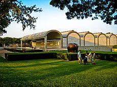 South Wing of the Kimbell Art Museum with a sculpture and garden in front.
