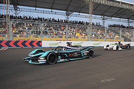 Mobil Formula E yang dikemudikan oleh Mitch Evans dari tim Jaguar TCS Racing dan Pascal Wehrlein dari tim Tag Heuer Porsche melintas di depan penonton di Jakarta International E-Prix Circuit (JIEC)