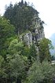 Blick vom Zustiegsweg auf den Felssporn mit dem Rundbogenfenster der Ruine etwa über der Bildmitte.