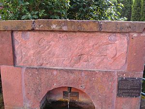 Brunnen mit eingemauertem Ritz-Relief „Walfisch spuckt Jonas aus“; Relief frühromanisch oder römisch-frühchristlich