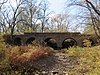 Stone bridge over stony creek bed among trees