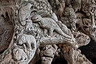 Carved tree with reliefs of dinosaur and other animals, Laos