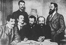 Von Links nach Rechts: Ignacy Mościcki, Bolesław Jędrzejowski, Józef Piłsudski, Aleksander Dębski. Stehend: Bolesław Miklaszewski, Witold Jodko-Narkiewicz