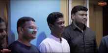 Santhi Soundarajan, an Indian athlete wearing white, stands between two masculine-presenting people.