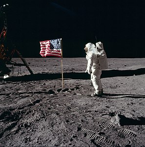 Ay'a ayak basan ikinci insan olan Buzz Aldrin uydunun yüzeyinde Amerika Birleşik Devletleri bayrağını selamlarken. Görev komutanı Neil Armstrong'un ardından Ay'a ayak basan Aldrin, dört gün süren görev boyunca üç kez ay yürüyüşü yapmıştır. (1969) (Üreten: Wilfredor)