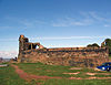 The walls of a ruined castle with one remaining arch