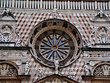 Zentrales Radfenster mit flankierenden Ädikulae. Unten, über dem Colleoni-Wappen auf dem Giebel stehend, Engelsstatue. Oben, antik gewandete Feldherren-Statue.