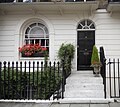 The front entrance to 46 Lower Belgrave Street. A basement window is visible through the railings.