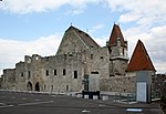 Im Vordergrund die Burgmauer, dahinter das Dach der Pfarrkirche, leicht rechts der Wehrturm und ganz rechts das Dach der Martinskapelle