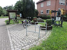 Dorfplatz mit Infotafel u. Wegweiser u. historischer Ölförderpumpe